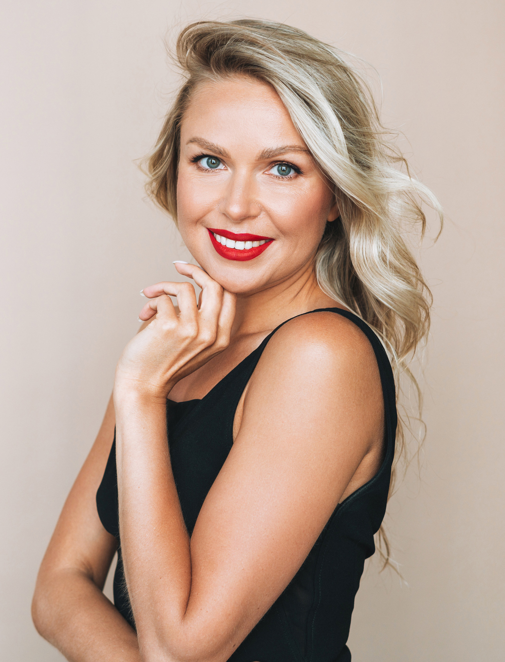 Portrait of gorgeous beautiful blonde young woman with bright makeup in evening dress on beige background MedSpa in Akron, OH