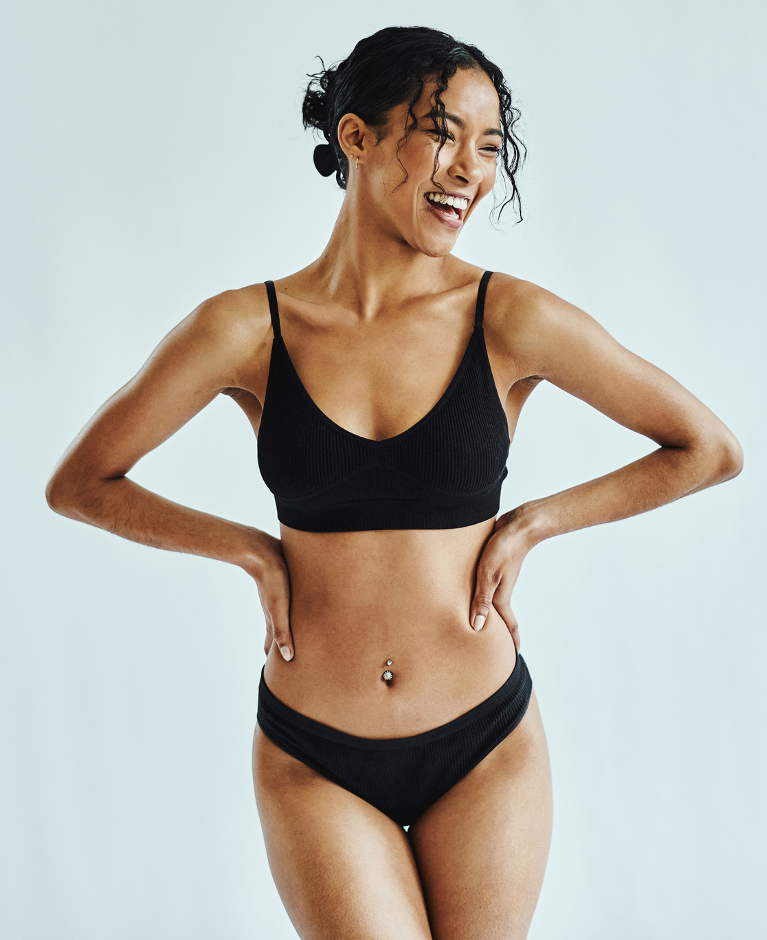 Happy, woman and lingerie in a studio for wellness, beauty and weight loss against a white background mockup. Health, black woman and underwear model posing, laughing and feeling confident mock up Plastic Surgery in Akron, OH